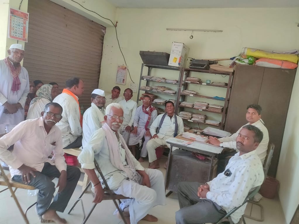 WhatsApp Image 2026-02-09 at 105646 - NewsNation Online A group of people sitting in a room with a desk and shelves filled with documents, some participants are engaged in conversation while others are observing.