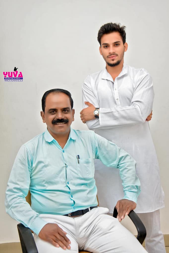 WhatsApp Image 2026-01-03 at 134910 - NewsNation Online Two men posing for a photograph. One man is seated wearing a light blue shirt, while the other, standing behind, is dressed in a white kurta.